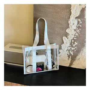 Detail view of transparent PVC tote bag with white fabric handles and inner pouch