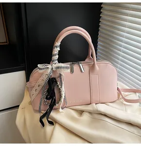 Detalle de bolso Boston de cuero PU rosa con lazo de cuadros blanco y negro y cremallera