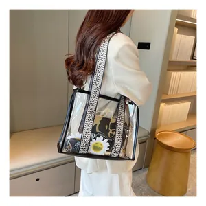 Detail view of transparent PVC tote bag with black trim and ethnic geometric strap