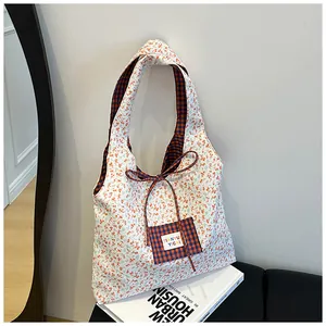 Detail of floral canvas tote bag with checkered pocket and bow tie closure