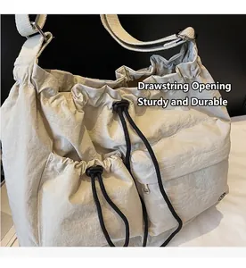 Detail view of the drawstring closure and durable nylon fabric on a beige crossbody bag