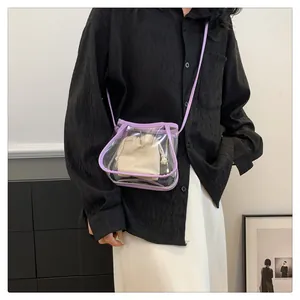 Close-up of clear purple crossbody bag with drawstring canvas pouch and leather strap