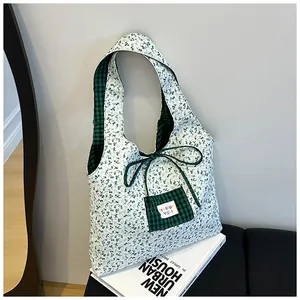 Detail of floral canvas tote bag featuring green checkered ribbon and front pocket