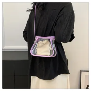 Detail of purple transparent PVC crossbody bag with cream drawstring linen inner pouch