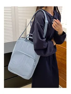 Detail of light blue waterproof nylon tote bag with zipper pocket and adjustable straps
