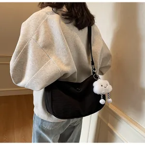 Detail of black corduroy crossbody bag with cute white cloud plush pendant accessory