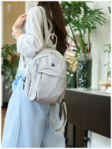 Close-up of lightweight grey nylon backpack featuring waterproof fabric and metal logo detail