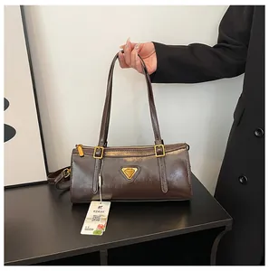 Detailansicht einer dunkelbraunen Kunstleder-Schultertasche mit goldenem Metall-Logo