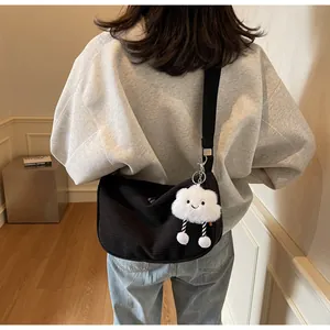 Detail of black corduroy crescent bag with adjustable strap and cute cloud charm