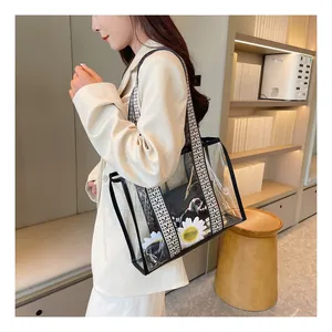 Detailed close-up of transparent PVC tote with black trim and patterned woven strap