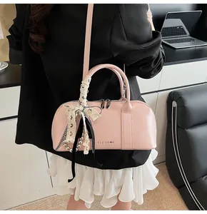 Bolso bowling de charol rosa con cinta de encaje y lazo de cuadros blancos y negros