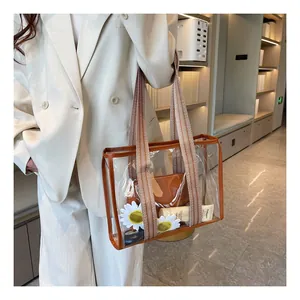 Close-up of a clear jelly tote bag with brown trim and striped woven shoulder strap