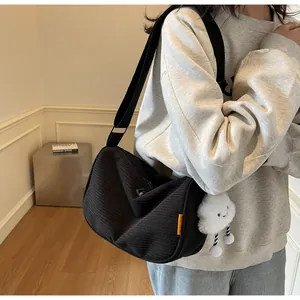 Detail of black corduroy crossbody bag with adjustable strap and cute cloud charm