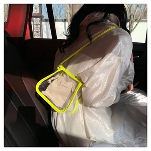 Dettaglio borsa a tracolla in PVC trasparente con bordi giallo neon e pochette interna