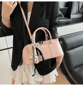Detalle de bolso boston rosa brillante con adorno de lazo de encaje y correa ajustable
