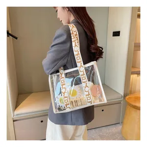 Detail of transparent jelly tote bag with printed wide strap and white reinforced stitching