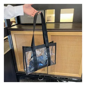 Close-up of transparent PVC tote bag featuring black canvas trim and matching inner pouch