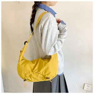 Dettaglio della borsa a mezzaluna in nylon giallo con coulisse laterali e design a pieghe