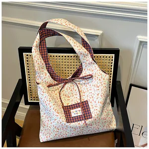 Detail of floral and plaid double-sided canvas tote bag on a woven chair