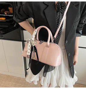 Bolso bandolera rosa minimalista con asa de pañuelo de seda en una cocina moderna