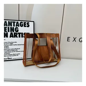 Close-up of a transparent PVC tote bag with an amber inner pouch and nylon handle details