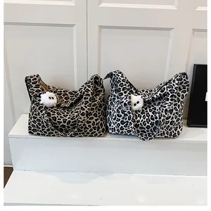 Détail de sacs cabas en toile léopard marron et noir et blanc avec breloques peluche