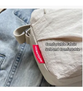 Detail of lightweight beige nylon fabric texture and red decorative label on side