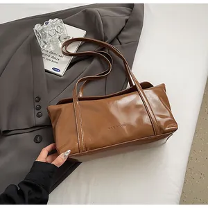 Detail of glossy brown oil wax leather shoulder bag featuring embossed GLEA R♥K logo