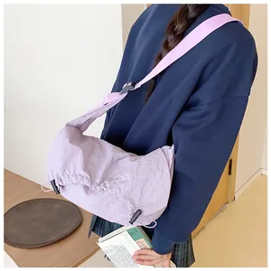 Dettaglio della borsa a mezzaluna lilla in nylon con coulisse e trama a pieghe naturale