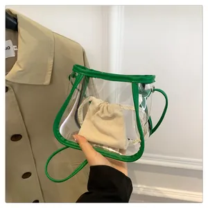 Detailed shot of transparent PVC tote with green leather trim and canvas drawstring inner bag