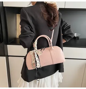 Detalle del bolso rosa con colgante de encaje y el logotipo de marca CLEAR K grabado