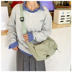 Dettaglio borsa a tracolla in nylon verde salvia con coulisse e tracolla larga