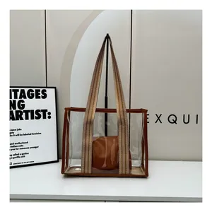 Detail view of transparent PVC tote bag with leather trim and thick woven shoulder strap