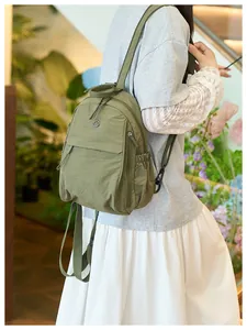 Army green nylon backpack on model showing large capacity side pocket and straps