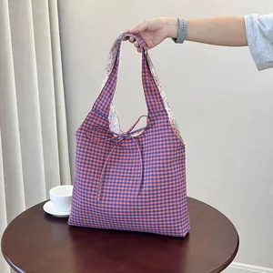 Blue and orange checkered tote bag with floral lining and a bow tie accent