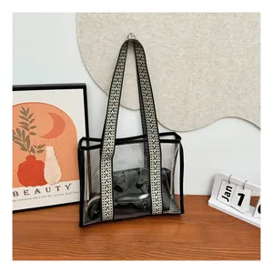 Detail of transparent PVC tote bag with black piping and wide geometric shoulder strap