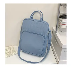 Close-up of light blue oxford fabric laptop tote bag with front zipper and dual handles