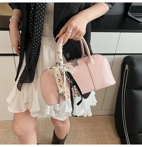 Detalle de bolso de cuero sintético rosa con lazo de encaje decorativo y cinta negra