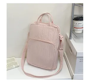 Detail of light pink oxford tote bag with quilted texture, dual handles and shoulder strap