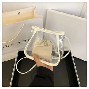 Close-up of transparent PVC crossbody bag with beige drawstring inner pouch detail