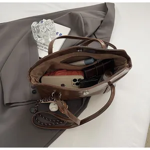 Brown oil wax leather tote bag shown open to reveal spacious capacity and interior pocket
