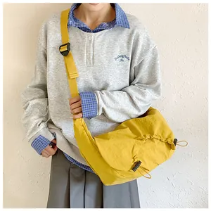 Dettaglio della borsa a mezzaluna giallo vivace con trama in nylon e tracolla regolabile