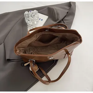 Interior view of brown faux leather tote bag with zipper pocket and magnetic buckle