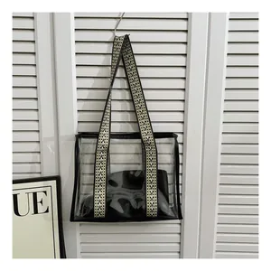 Detail of transparent PVC tote bag with stylish V-shaped geometric woven shoulder straps