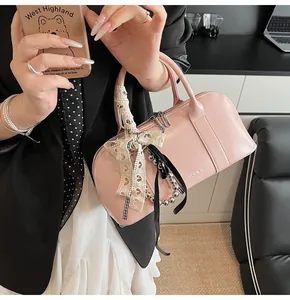 Detalle de bolso de cuero rosa con lazos de encaje, cinta y adornos de cuentas de plata