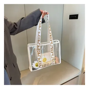 Detail of transparent PVC tote with patterned wide strap and floral inner pouch