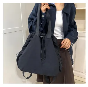 Detailopname van nylon hobo tas met trekkoordsluiting en brede schouderriem