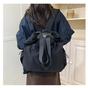 Detail van de zwarte nylon schoudertas met trekkoord en verstelbare gesp aan de zijkant
