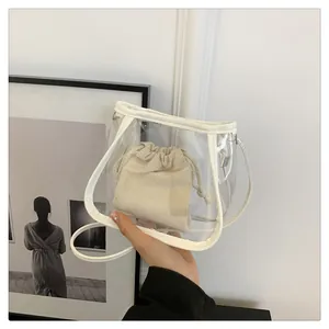Close-up of transparent PVC bucket bag featuring white trim and a canvas drawstring inner pouch