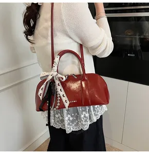 Detalle del bolso de hombro en cuero PU rojo brillante con lazo de encaje y perlas